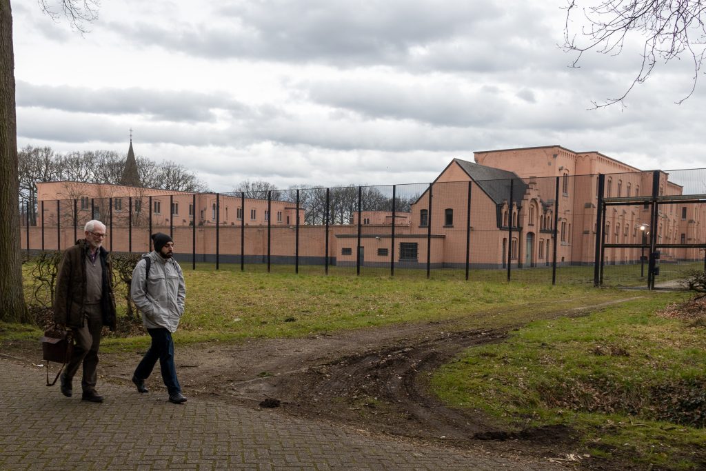 Two men walking by a detention centre