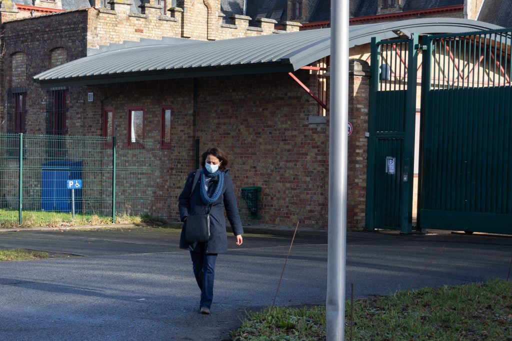 Woman wearing a mask leaving a detention centre